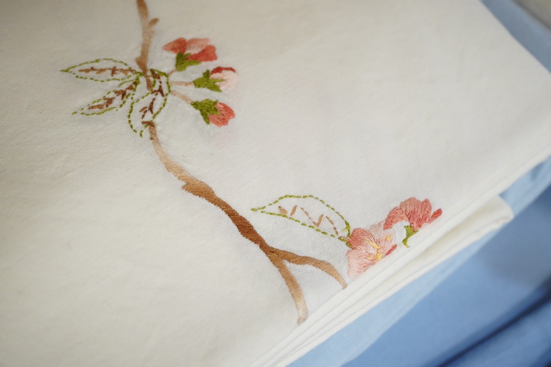 Thirteen mixed French mostly coloured provincial linen sheets some embroidered with monograms, floral embroidery, or decorated with crochet.
